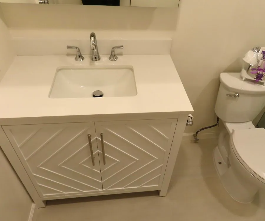 White bathroom vanity with sink and toilet